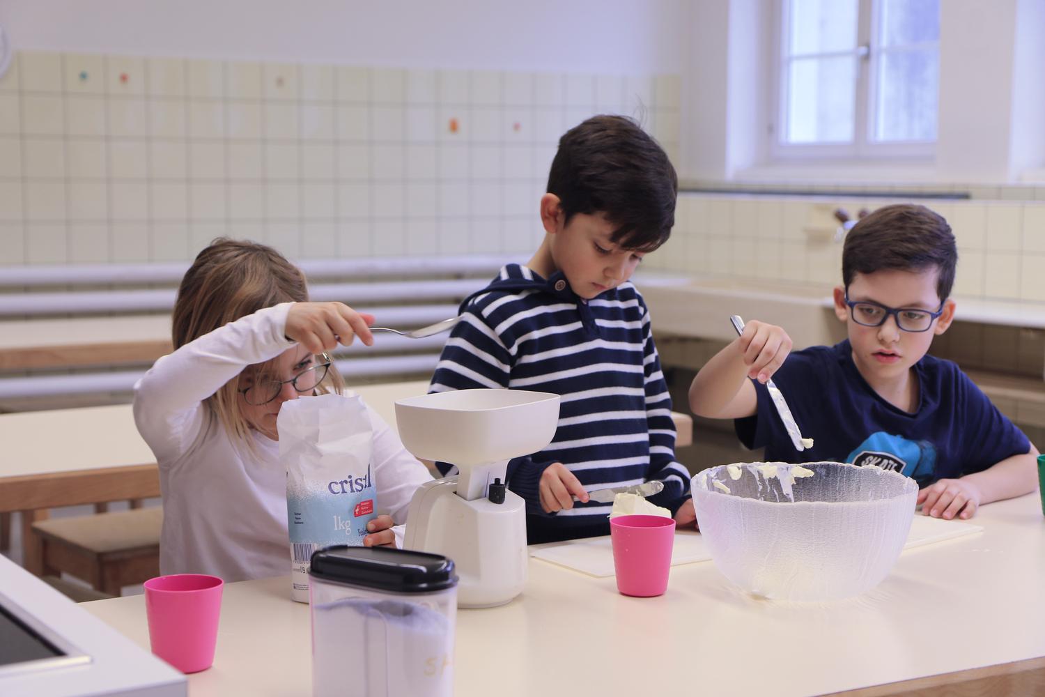 Kinder backen gemeinsam in der Schulküche